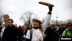 A baker holds a loaf of bread during a demonstration of French bakers and artisans to demand governmental aid in the face of soaring energy prices, in Paris, France, Jan. 23, 2023. 