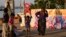 Street children play with red ribbon left on display by activists on the banks of the Hooghly River ahead of World AIDS Day in Kolkata, India, Nov. 30, 2022.