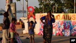 Street children play with red ribbon left on display by activists on the banks of the Hooghly River ahead of World AIDS Day in Kolkata, India, Nov. 30, 2022.