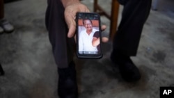 A bus driver shows photo of late coworker Nehemias Verdugo Trejo who was killed by gunmen in Feb. 24, 2022, at a bus station in Huixtla, Mexico, Jan. 19, 2023.