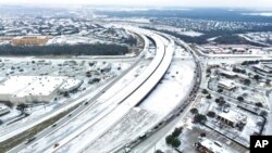 Una mezcla helada cubre la autopista 114 el lunes 30 de enero de 2023 en Roanoke, Texas. Dallas y otras partes del norte de Texas están bajo advertencia de tormenta invernal hasta el miércoles. (Lola Gómez/The Dallas Morning News vía AP)