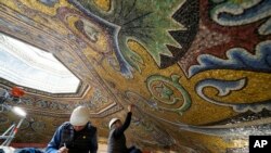 Restorers Chiara Zizola, right, and Roberto Nardi work on the restoration of the mosaics that adorn the dome of one of the oldest churches in Florence, St. John's Baptistery, in Florence, central Italy, Feb. 7, 2023.