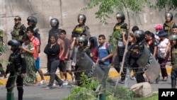 Alleged protesters wait to be transferred after being arrested by police on the campus of the University of San Marcos in Lima, Peru, on Jan. 21, 2023.