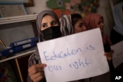Perempuan, guru, dan siswa berdemonstrasi di dalam sekolah swasta untuk menuntut hak-hak mereka dan pendidikan yang setara bagi perempuan dan anak perempuan, dalam acara Hari Guru Nasional, di Kabul, Afghanistan, Selasa, 5 Oktober 2021. (Foto: AP)