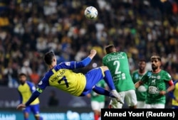 Cristiano Ronaldo saat bersanding dengan Saeed Al-Mowalad dari Al Ettifaq. (Foto: REUTERS/Ahmed Yosri)