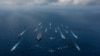 FILE - The aircraft carrier USS Ronald Reagan and the Japanese helicopter destroyer JS Hyuga sail in formation with 16 other ships from the US and Japan in the Philippine Sea, Nov. 8, 2018.