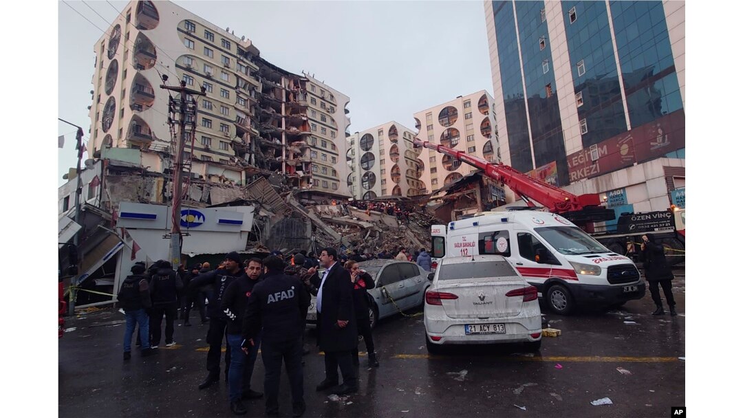 Petugas penyelamat dan tim medis berusaha menjangkau warga yang terjebak di bangunan runtuh menyusul gempa bumi di Diyarbakir, tenggara Turki, Senin dini hari, 6 Februari 2023. (Foto: AP)