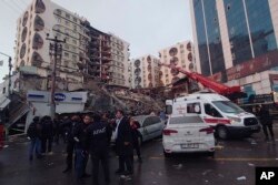Petugas penyelamat dan tim medis berusaha menjangkau warga yang terjebak di bangunan runtuh menyusul gempa bumi di Diyarbakir, tenggara Turki, Senin dini hari, 6 Februari 2023. (Foto: AP)