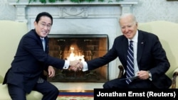 U.S. President Joe Biden shakes hands with Japan's Prime Minister Fumio Kishida in Washington.