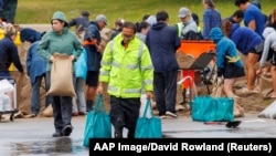 People fill sandbags at a public collection point in preparation for the arrival of a sub-tropical low-pressure system known as Gabrielle in Auckland, New Zealand, Feb. 12, 2023.