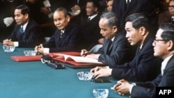 Ảnh chụp các đại diện của Bắc Việt Nam, trong đó Bộ trưởng Ngoại giao Nguyễn Duy Trinh (thứ ba từ phải) đang kí thỏa thuận ngừng bắn để chấm dứt chiến tranh ở Việt Nam, tại Paris, Pháp, ngày 27 tháng 1 năm 1973.