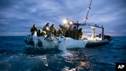 امریکی بحریہ کی طرف سے فراہم کردہ اس تصویر میں ایکسپلوسیو آرڈیننس ڈسپوزل گروپ 2 کےملاحوں کو دکھایا گیا ہے جو مرٹل بیچ، پر ساحل سے ایک اونچائی پر نگرانی کرنے والے غبارے کو نکال رہے ہیں۔ (US Navy via AP)