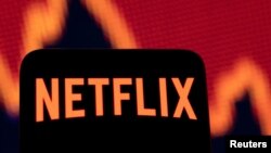 Un teléfono inteligente con el logotipo de Netflix se ve frente a un gráfico de acciones en esta ilustración tomada el 19 de abril de 2022.