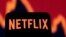 Un teléfono inteligente con el logotipo de Netflix se ve frente a un gráfico de acciones en esta ilustración tomada el 19 de abril de 2022.