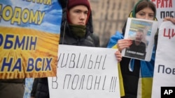 In this photo provided by public organization "Civilians in captivity", relatives of civilian prisoners attend an action in centre of Kyiv, Ukraine, Dec. 24, 2022.