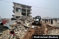 Tim penyelamat mencari korban selamat di bawah reruntuhan, setelah bencana gempa bumi, di Kota Jandaris yang dikuasai pemberontak, Suriah, 6 Februari 2023. (Foto: REUTERS/Khalil Ashawi)