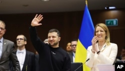 在布鲁塞尔欧洲议会召开的一次欧盟峰会上，乌克兰总统泽连斯基挥手致意，欧洲议会议长梅措拉在旁鼓掌。(2023年2月9日)