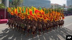 Sri Lankan government soldiers march carrying national flags during the 75th Independence Day ceremony in Colombo, Sri Lanka, Feb. 4, 2023