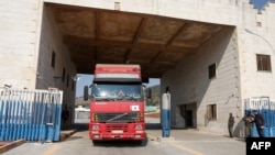 FILE - Trucks carrying tent and shelter kits provided by the United Nations in the wake of a deadly earthquake enter Syria's Bab al-Hawa border crossing with Turkey in the rebel-held northwestern province of Idlib, Feb. 12, 2023. 