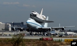 FILE - The Space Shuttle Endeavour atop a modified 747 lands at Los Angeles International Airport on Friday, Sept. 21, 2012 in Los Angeles, California. (AP Photo/Kevork Djansezian, Pool)