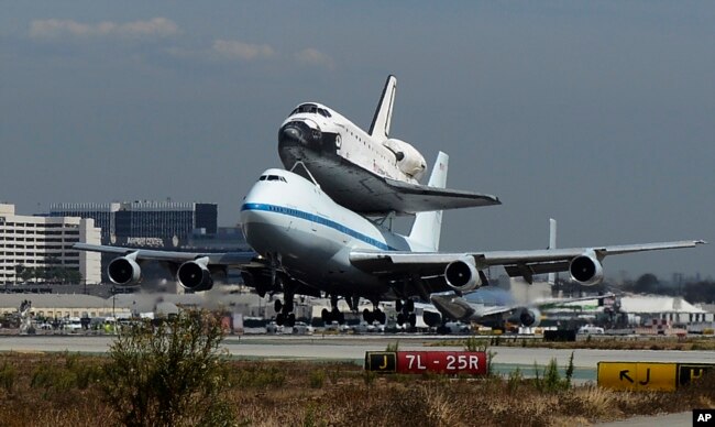 FILE - The Space Shuttle Endeavour atop a modified 747 lands at Los Angeles International Airport on Friday, Sept. 21, 2012 in Los Angeles, California. (AP Photo/Kevork Djansezian, Pool)