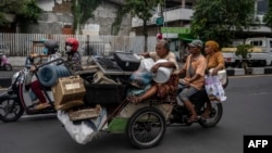 Becak berisi barang bekas yang akan dijual ke pasar loak di Surabaya, 1 Februari 2023. (Foto: JUNI KRISWANTO/AFP)