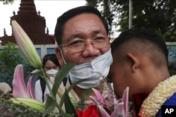 Thach Setha, vice president of the country's main opposition Candlelight Party, hugs a boy in front of the Prey Sar main prison outside Phnom Penh, Cambodia, on November 10, 2021. (Heng Sinith/AP)