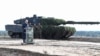 FILE - German Chancellor Olaf Scholz delivers a speech in front of a Leopard 2 tank during a visit to a military base of the German army Bundeswehr in Bergen, Oct. 17, 2022.