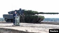 FILE - German Chancellor Olaf Scholz delivers a speech in front of a Leopard 2 tank during a visit to a military base of the German army Bundeswehr in Bergen, Oct. 17, 2022.