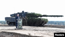 资料照 - 德国总理朔尔茨2022年10月17号视察卑尔根德国联邦国防军陆军基地时站在一辆豹2坦克前发表讲话。