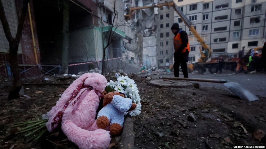 人们在俄罗斯导弹袭击乌克兰第聂伯罗居民楼废墟现场放置的悼念物品。(2023年1月16日)(photo:VOA)