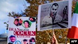 (FILE) People hold portraits of Iranian rapper Toomaj Salehi, right, and children, left, who were killed during the protests in Iran, during a rally in Istanbul, on Nov. 26, 2022. 