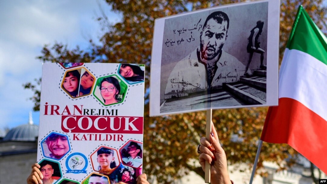 FILE - Aksi protes warga di Istanbul, dengan memegang potret rapper Iran Toomaj Salehi (kanan), dan anak-anak (kiri) yang terbunuh selama protes di Iran, 26 November 2022.