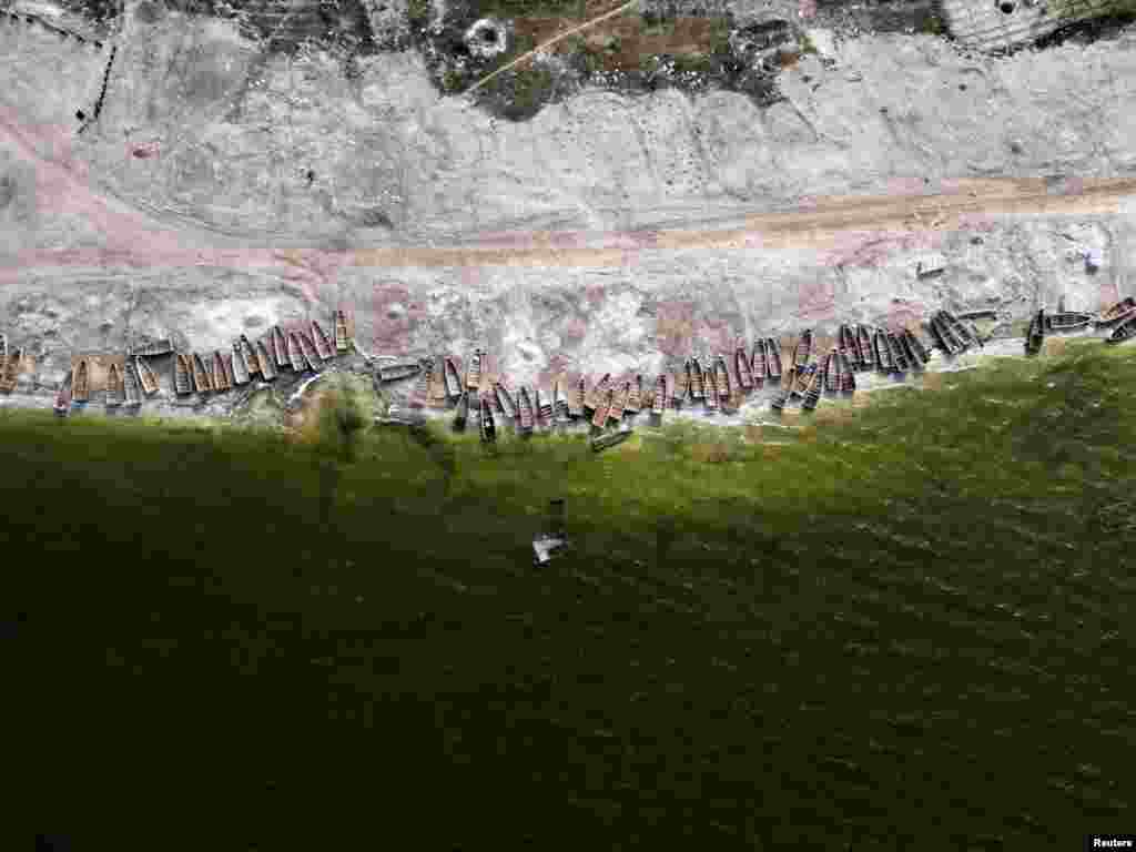 Пироги лежат на брегот на Розовото Езеро, официјално познато како езерото Ретба, откако екстремните поплави ги однесоа наслагите на сол и го загадија езерото и ги претворија неговите познати води од розово во зелено, во Нијага, во близина на Дакар, Сенегал.