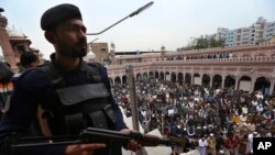 Polisi berjaga saat warga melaksanakan salat Jumat di sebuah masjid di Peshawar, Pakistan, Jumat, 3 Februari 2023. (AP Photo/Muhammad Sajjad)