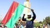 Un homme tient un drapeau national lors d'un rassemblement après le coup d'État qui a renversé le président Roch Kaboré, à Ouagadougou, au Burkina Faso, le 25 janvier 2022.