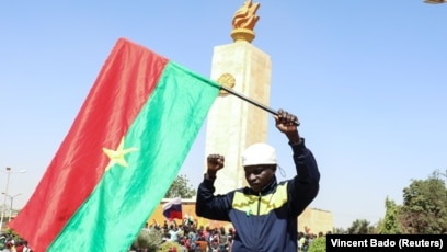 Un homme tient un drapeau du Burkina Faso lors d'un rassemblement de souteien au coup d'État qui a renversé le président Roch Kaboré, Ouagadougou le 25 janvier 2022. REUTERS/Vincent Bado