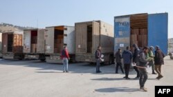 Men inspect the cargo of trucks carrying aid supplies provided by the United Nations in the aftermath of a deadly earthquake, at Syria's Bab al-Hawa border crossing with Turkey, in the rebel-held northwestern Idlib province, Feb. 12, 2023.