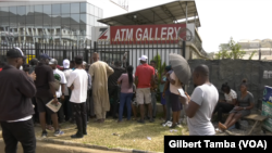 Des Nigérians attendent devant un distributeur de billets de banque pour faire des retraits, Abuja, le 9 février 2023. (VOA/Gilbert Tamba) 