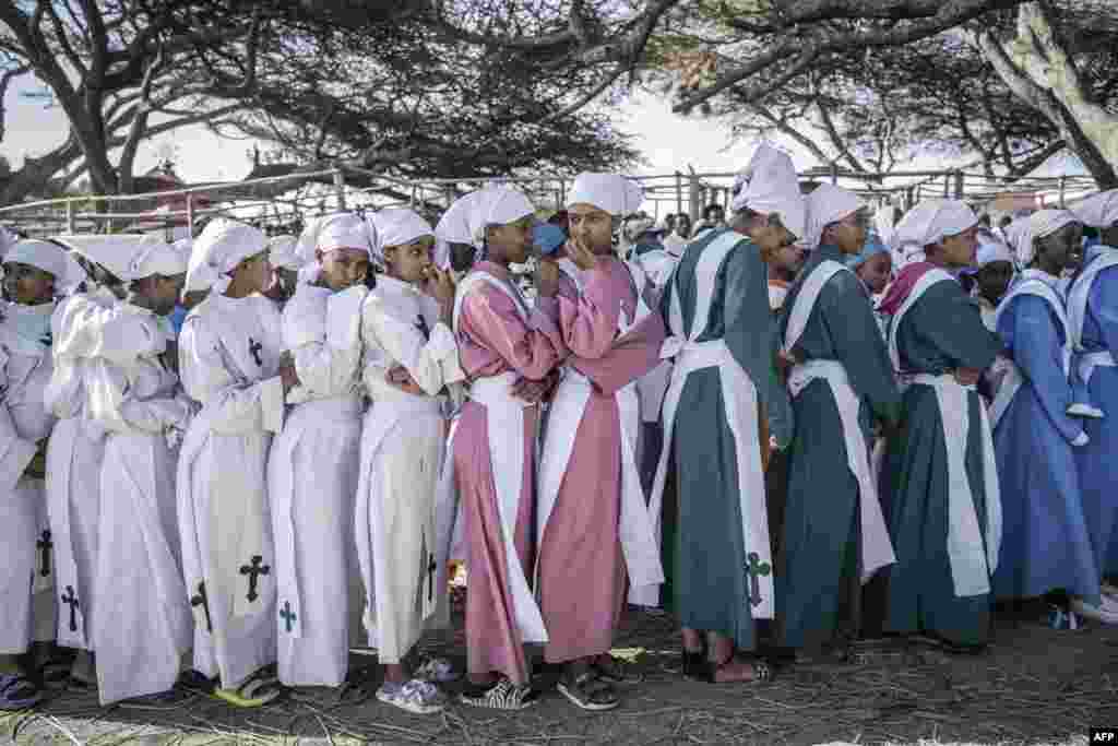 Ethiopian Orthodox devotees attend a prayer during the celebration of the Ethiopian Epiphany on the shore of lake Ziway, Ethiopia.