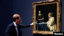 Director of Rijksmuseum Amsterdam Taco Dibbits looks at Vermeer's painting 'Mistress and Maid' at an exhibition bringing together 28 works by Dutch painter Johannes Vermeer in Amsterdam, Netherlands February 6, 2023. (REUTERS/Piroschka van de Wouw)