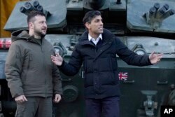 El primer ministro británico, Rishi Sunak, y el presidente ucraniano, Volodymyr Zelenskyy, se reúnen con las tropas ucranianas que están siendo entrenadas para comandar los tanques Challenger 2 en una instalación militar en Lulworth, Dorset, Inglaterra, el miércoles 8 de febrero de 2023.