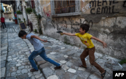 قدیم شہر انطاکیہ کی ایک گلی میں دو بچے نقلی پستول کے ساتھ کھیل رہے ہیں۔