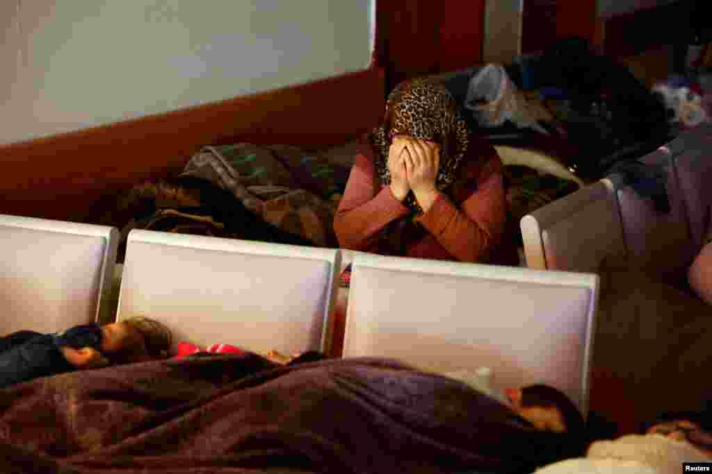 Survivors rest while a woman reacts at a hospital in the aftermath of an earthquake, in Kahramanmaras, Turkey.