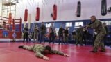 Participants watch instructors during military training for civilians at the sports and patriotic club "Yaropolk" in Krasnogorsk, outside Moscow, Russia, Dec. 3, 2022.  