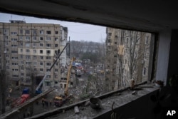 FILE - Rescue workers clear the rubble from an apartment building that was destroyed in a Russian rocket attack at a residential neighborhood in the southeastern city of Dnipro, Ukraine, Jan. 16, 2023.