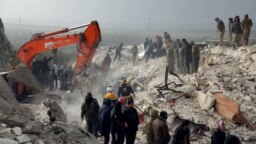 Residents and rescuers search for victims and survivors amidst the rubble of collapsed buildings following an earthquake in the village of Besnaya in Syria's rebel-held northwestern Idlib province on the border with Turkey, on Feb.6, 2022.