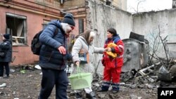 ARCHIVO - Una pareja abandona su casa parcialmente destruida por un misil ruso dirigido contra una zona residencial en Kharkiv, el 5 de febrero de 2023, a pocos días del primer año del comienzo de la invasión rusa a Ucrania.