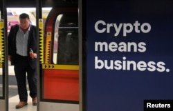 A rail passenger passes an advertisement promoting cryptocurrency investment at a London Underground station in London, Britain, November 14, 2022. (REUTERS/Toby Melville)