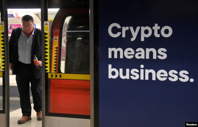 A rail passenger passes an advertisement promoting cryptocurrency investment at a London Underground station in London, Britain, November 14, 2022. (REUTERS/Toby Melville)